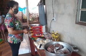 Dona Cleusa em casa organizando os alimento recebidos